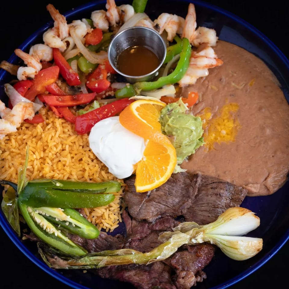 El Tenampa's Mexican platter with shrimp, steak, rice, beans, guacamole, sour cream, and grilled vegetables.